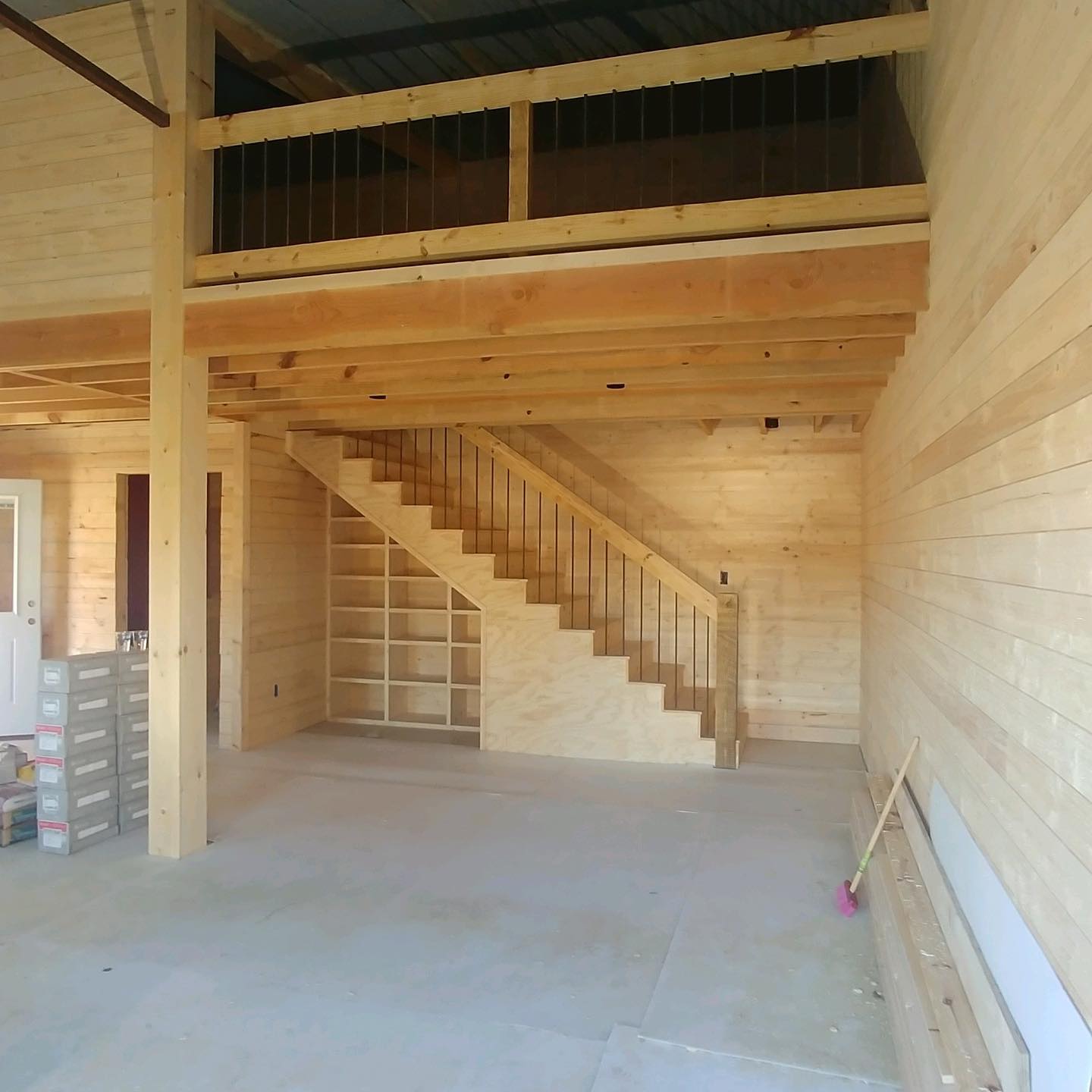 Custom barndominium interior — tongue and groove walls, open loft, built-in shelving